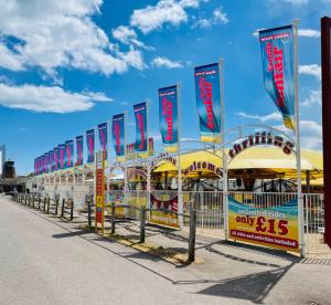 a carnival ride with colorful flags on the street at WestSands Caravan in Selsey