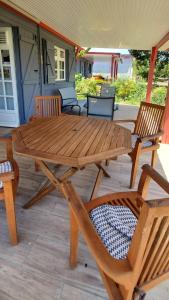 una mesa de picnic de madera y sillas en un porche en Cotton residences, en Sainte-Anne