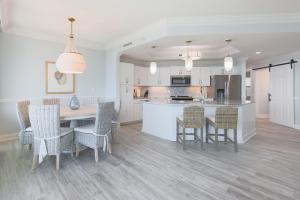 Una cocina y un comedor con mesa y sillas. en Phoenix on the Bay 1506 condo, en Orange Beach