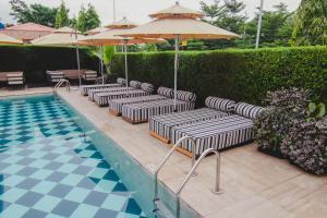 eine Reihe von Liegestühlen neben einem Pool in der Unterkunft BON Hotel Imperial in Abuja