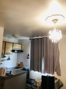 a kitchen with a chandelier hanging from a ceiling at Week-end Porte de Clichy in Clichy