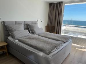 a bed in a room with a view of the ocean at Traumwohnung mit Meerblick über die Ostsee in Kiel
