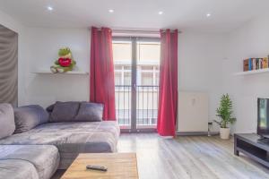 a living room with a couch and red curtains at Arbeitsplatz, Tiefgaragenstellplatz, 4k TV Netflix in Leipzig