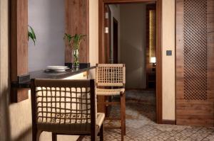cocina con mesa, 2 sillas y barra en فندق ايليت الهجرة en Medina