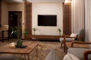 a living room with a television on a wall at فندق ايليت الهجرة in Medina