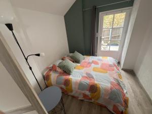 a bedroom with a bed with a colorful comforter and a window at Chanoine Boursier in Dol-de-Bretagne