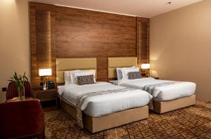 una habitación de hotel con 2 camas en una habitación en فندق ايليت الهجرة en Medina