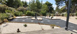 un jardin avec un parc avec des gens qui se promènent dans l'établissement Cottage du Lac, à Olonzac