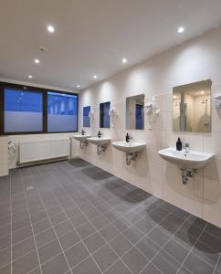 a bathroom with three sinks and three mirrors at sleep1c in Hamburg