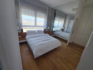 a bedroom with a bed and a couch and a mirror at Ocean View in Bat Yam