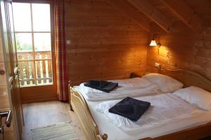 1 dormitorio con 1 cama con 2 almohadas negras en Waldkraft Hütte, en Elsenbrunn