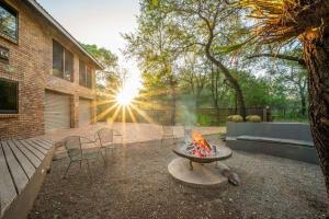 玛洛斯帕克Nokuthula Bush Retreat的一个带火坑和椅子的后院和一座建筑
