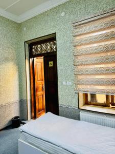Ένα ή περισσότερα κρεβάτια σε δωμάτιο στο SHUKRONA Hotel