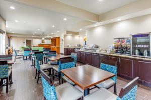 a restaurant with tables and chairs and a bar at Comfort Inn & Suites Temple - Medical Center in Temple