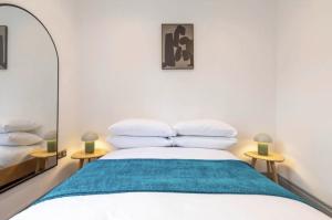 een slaapkamer met een bed en een spiegel bij Urban Chic: Stylish 1-Bed in the Heart of the City in Londen