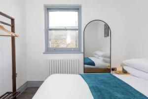 een slaapkamer met 2 bedden en een spiegel bij Urban Chic: Stylish 1-Bed in the Heart of the City in Londen