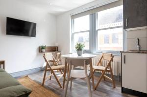 een keuken en een woonkamer met een tafel en stoelen bij Urban Chic: Stylish 1-Bed in the Heart of the City in Londen