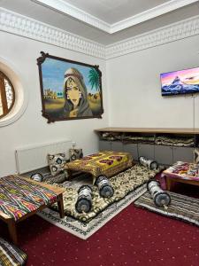 Cette chambre comprend deux lits et un tableau mural. dans l'établissement SHUKRONA Hotel, à Samarcande