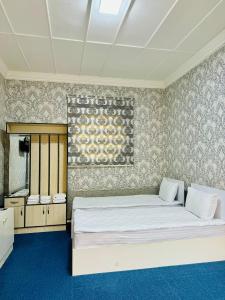 ein Schlafzimmer mit einem großen weißen Bett in einem Zimmer in der Unterkunft SHUKRONA Hotel in Samarkand