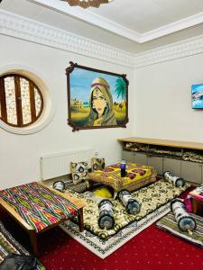 Cette chambre comprend deux lits et un tableau mural. dans l'établissement SHUKRONA Hotel, à Samarcande
