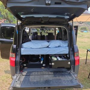 an open trunk of a van with a bed in it at Mini Camper Honda Element in Guatemala