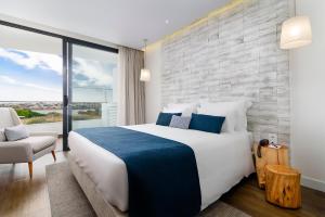 sypialnia z dużym łóżkiem i dużym oknem w obiekcie Jupiter Marina Hotel - Couples & Spa w mieście Portimão