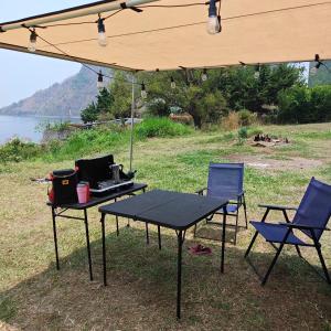a picnic table and two chairs under a tent at Mini Camper Honda Element in Guatemala