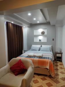 a bedroom with a large bed and a couch at Hotel Los Inkas in Huaraz