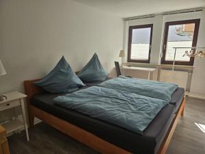 a bedroom with a bed with blue pillows on it at Becks schöne Ferienwohnung in Vogtsburg