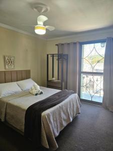 a bedroom with a bed with a stuffed animal on it at Pousada Araucária in Campos do Jordão