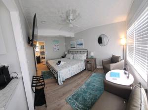 a bedroom with a bed and a couch and a table at Saltaire Cottages in Kitty Hawk Beach