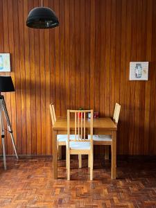 uma mesa de madeira com duas cadeiras e um candeeiro em Studio DOWNTOWN em Porto