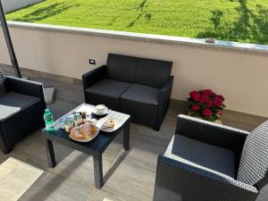 a patio with two chairs and a table with food on it at Villa Abenante Pompei in Scafati
