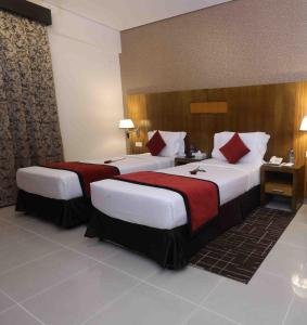 um quarto de hotel com duas camas num quarto em City Tower Hotel em Fujairah