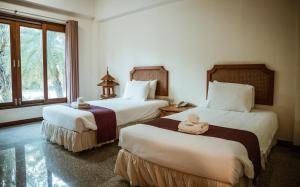 ein Hotelzimmer mit 2 Betten und Handtüchern darauf in der Unterkunft Tak Andaman Resort & Hotel in Tak