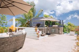 un patio con un bar al aire libre con sombrilla en Casa vista al mar y las montañas río san Juan a solo 4 minutos de centro del pueblo y las playas en Río San Juan