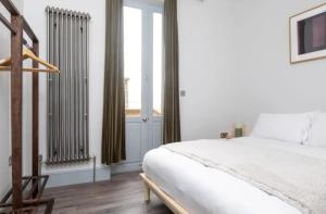 een slaapkamer met een wit bed en een raam bij Stylish Apt - Newly refurbished - Private Terrace in Londen
