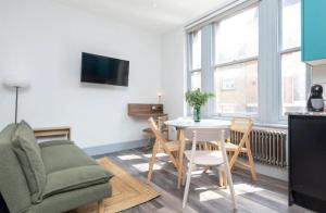 een woonkamer met een bank en een tafel bij Stylish Apt - Newly refurbished - Private Terrace in Londen