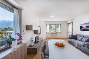a kitchen and living room with a table and a couch at Riviera Beach House in Calceranica al Lago