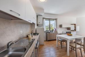 a kitchen with a sink and a table at Riviera Beach House in Calceranica al Lago