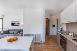 a kitchen and living room with a white counter top at Riviera Beach House in Calceranica al Lago