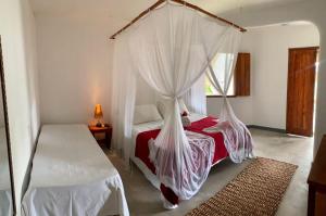 a bedroom with two beds with mosquito nets at Pousada Cores do Mar Caraíva in Caraíva +87 photos