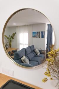 ein Wohnzimmer mit einem blauen Sofa im Spiegel in der Unterkunft Calvario 53 by 7Escalones in Rota