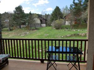 een balkon met een tafel en uitzicht op een veld bij charmant T2 formiguères les esplaneilles in Formiguères