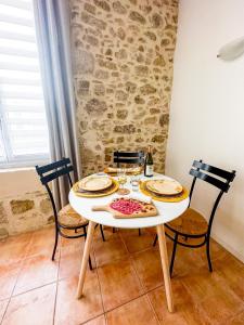 a table with two chairs and a white table with food on it at Cozy - Centre Historique - Gare à proximité - Grande Terrasse in Béziers