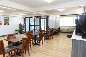 a dining room with tables and chairs and a tv at Coratel Inn & Suites by Jasper Mankato in Mankato