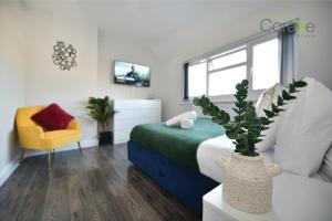a bedroom with a bed and a vase with a plant at 3 Bedroom Blissful Living for Contractors and Families Choice by Coraxe Short Stays in Tilbury