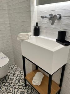 a white bathroom with a sink and a toilet at Central44 Luxury Apartment Ermou in Athens +36 photos