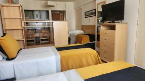 a hotel room with two beds and a flat screen tv at Callao Suites Recoleta in Buenos Aires