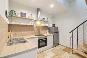 a kitchen with a sink and a refrigerator at LE LOGY-COSY - Appartement 5 pers - Clim Wifi Cosy Garage in Saint-Gilles